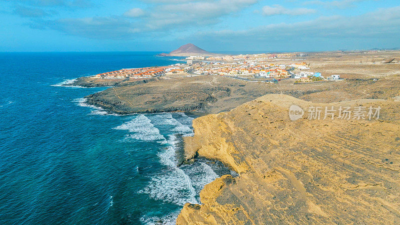 Aerial view of the coast in the natural reserve of "Montaña Pelada" and town of El Medano in the background. Tenerife, Canary Islands. Drone shot